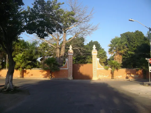 Entrada de hacienda con portón y árboles
