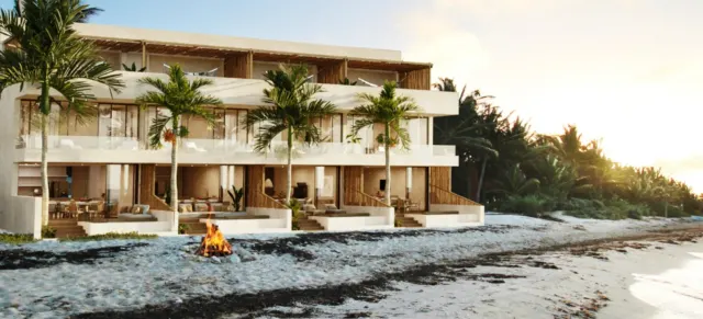 Edificio frente a la playa con palmeras al atardecer